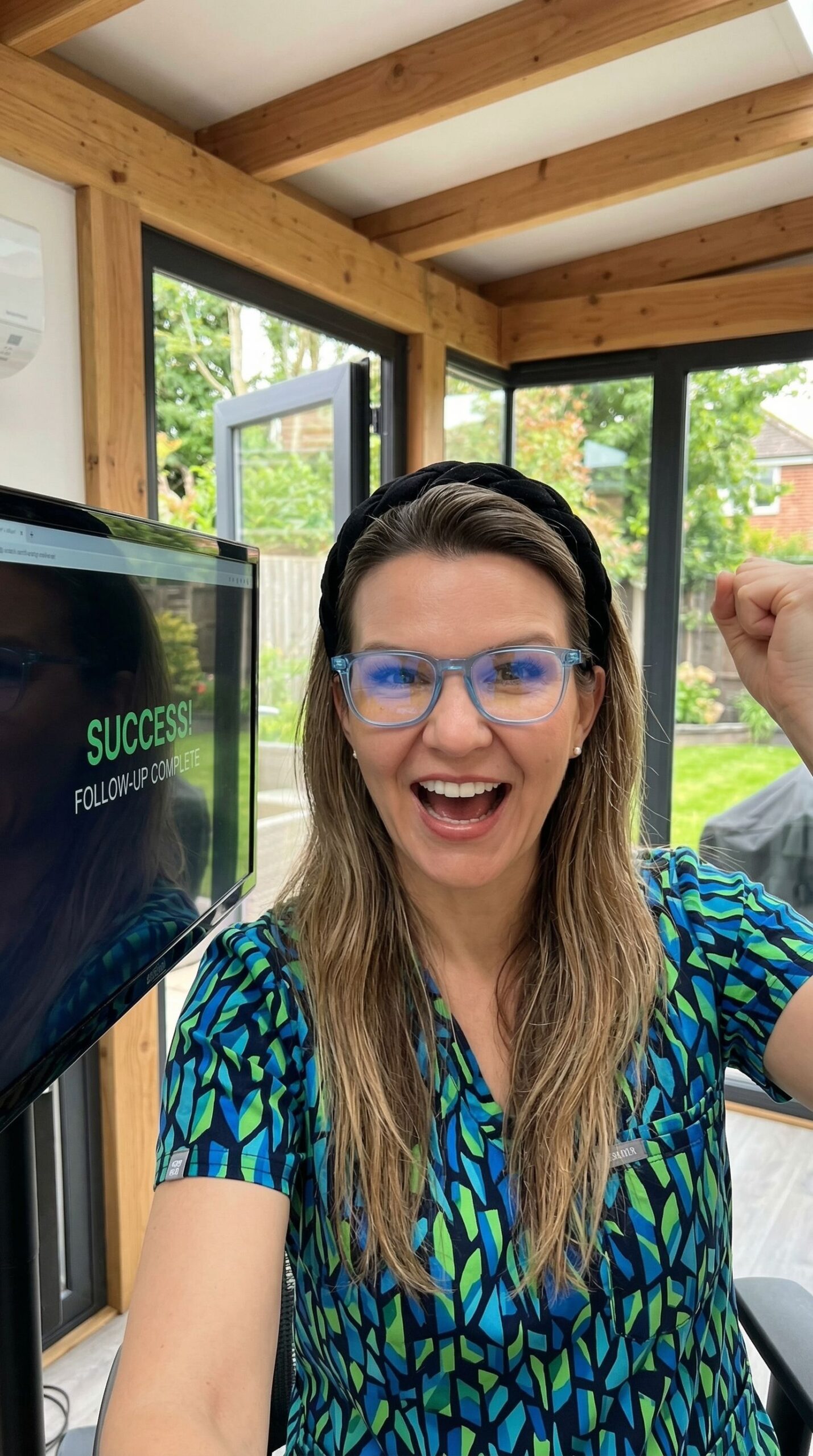 Asthma inhaler attached to a spacer device on a wooden desk beside a warm mug of tea.